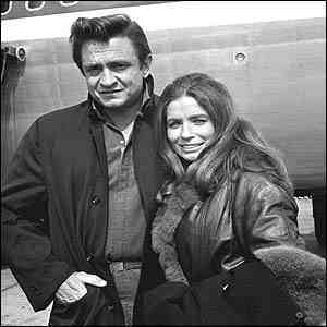 Johnny Cash and June Carter in front of an airplane